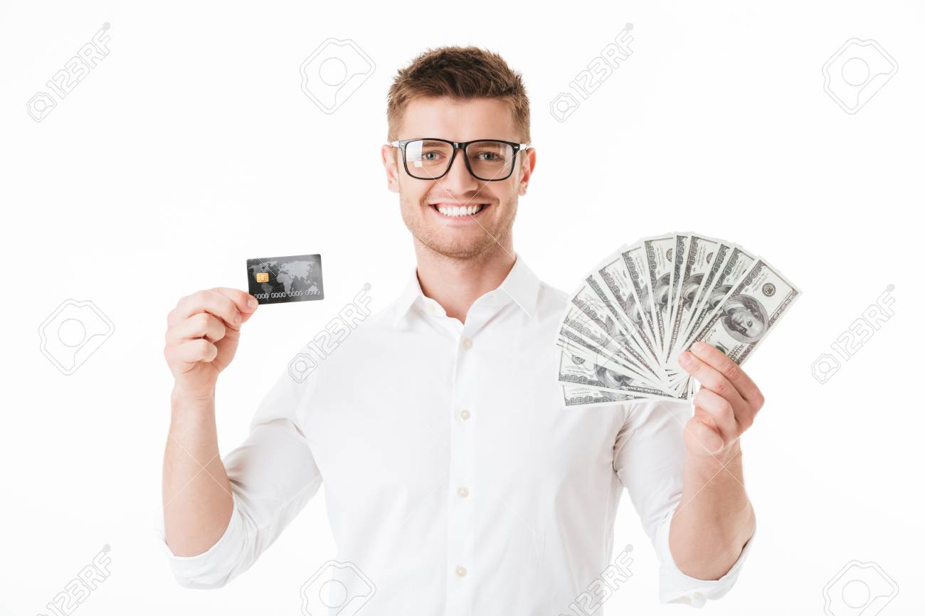Portrait Of A Happy Young Man In Eyeglasses Holding Money Banknotes - portrait of a happy young man in eyeglasses holding money banknotes and showing plastic credit card