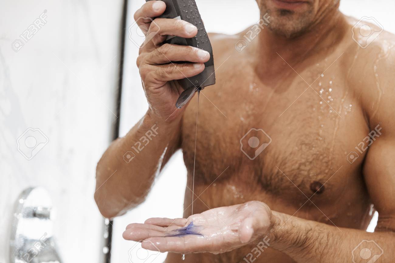 Close Up Of A Sexy Naked Man Putting Shower Gel From A Bottle While Having A Close Up Of A Sexy Naked Man Putting Shower Gel From A Bottle While Having A