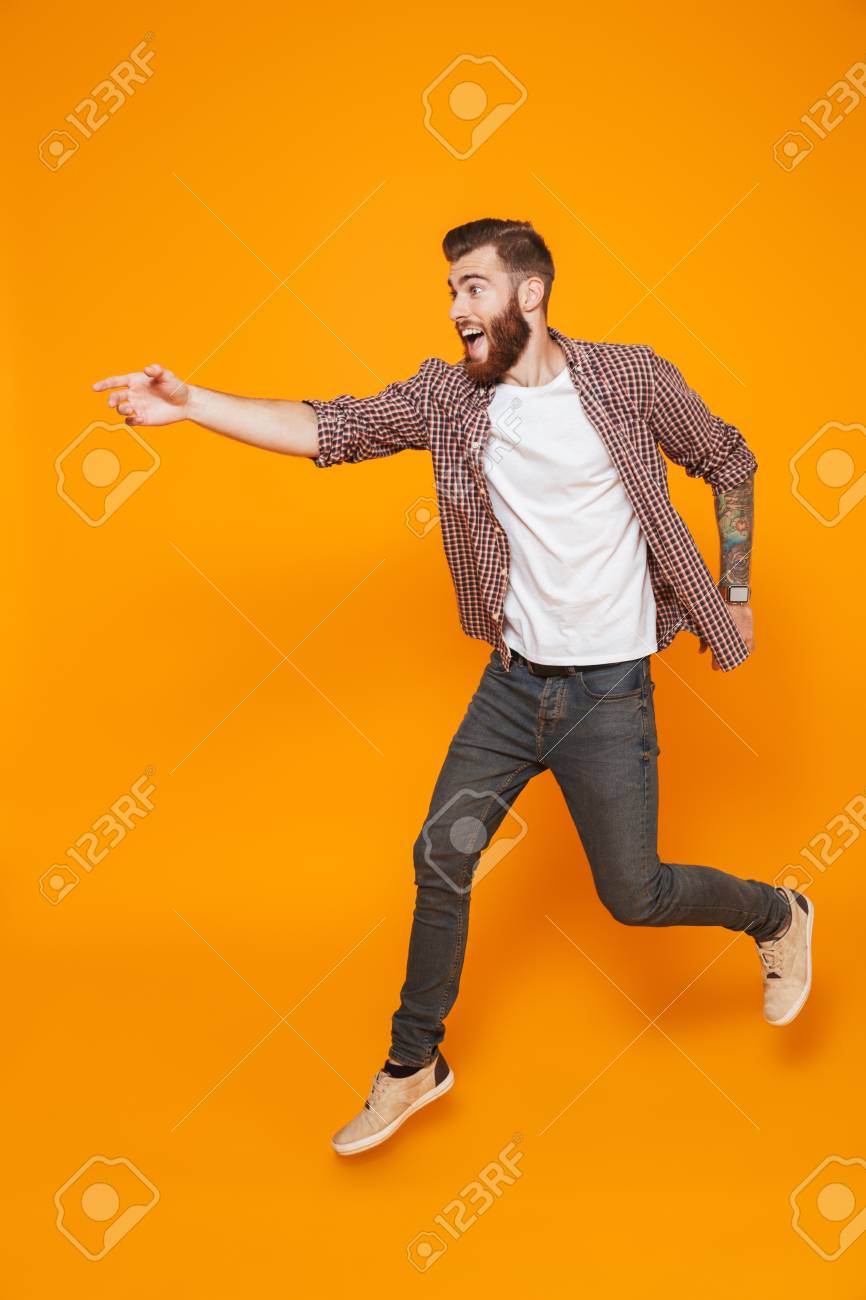 Full length portrait of a cheerful young man wearing casual clothes running away - 117906728 Full length portrait of a cheerful young man wearing casual clothes running away - 117906728