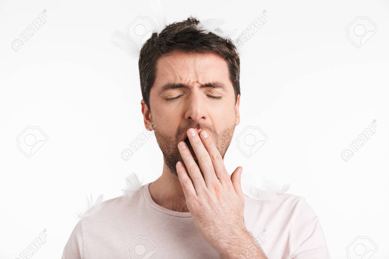 Image of sleepy man 30s with bristle in casual t-shirt yawning while standing under falling feathers isolated over white background - 121189800 Image of sleepy man 30s with bristle in casual t-shirt yawning while standing under falling feathers isolated over white background - 121189800