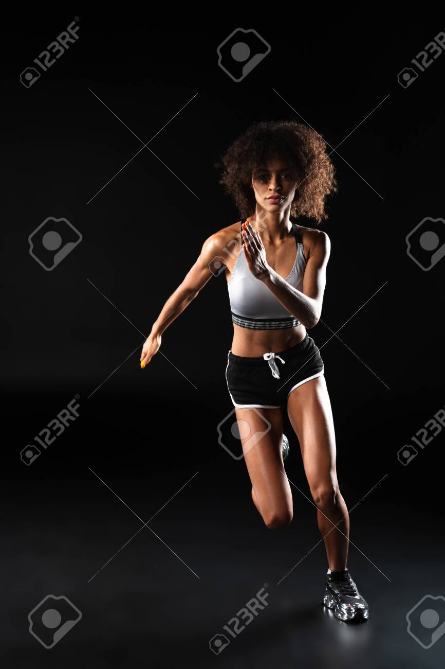 Image of focused african american sportswoman doing exercise while working out isolated over black background - 144494078 Image of focused african american sportswoman doing exercise while working out isolated over black background - 144494078