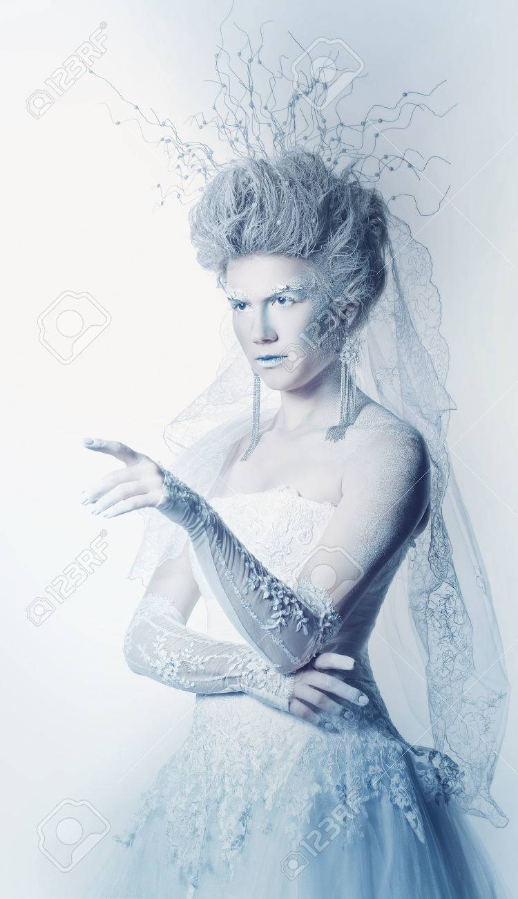雪の女王のフォームで顔アートの神秘的で珍しい女の子 女の子は白いドレスに身を包んだ 高い髪型です 妖精は人差し指をどこかを示します 風邪の王国のコンセプトです の写真素材 画像素材 Image