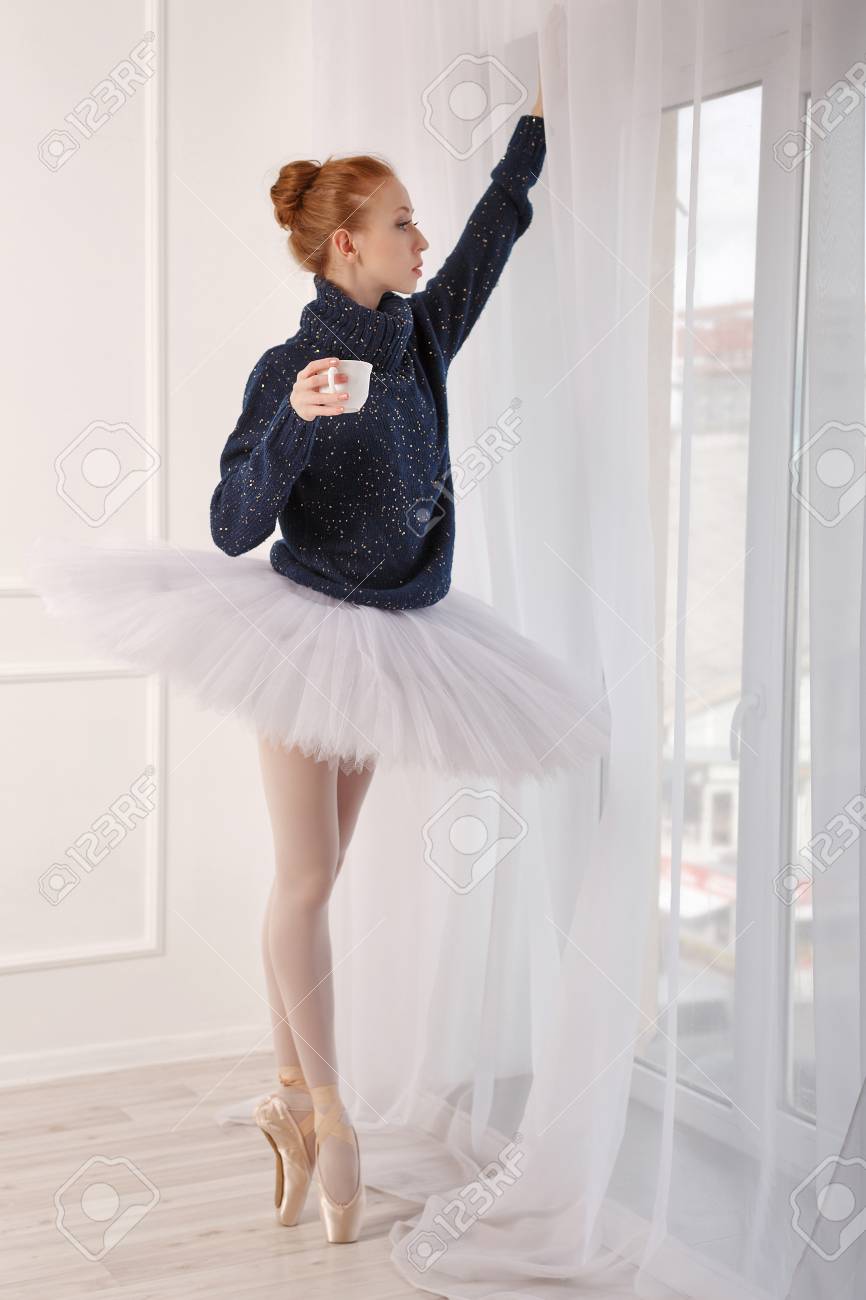 かなり若いバレリーナのドリンクの窓際の紅茶です チュチュと黒のセーターを着ている少女 の写真素材 画像素材 Image