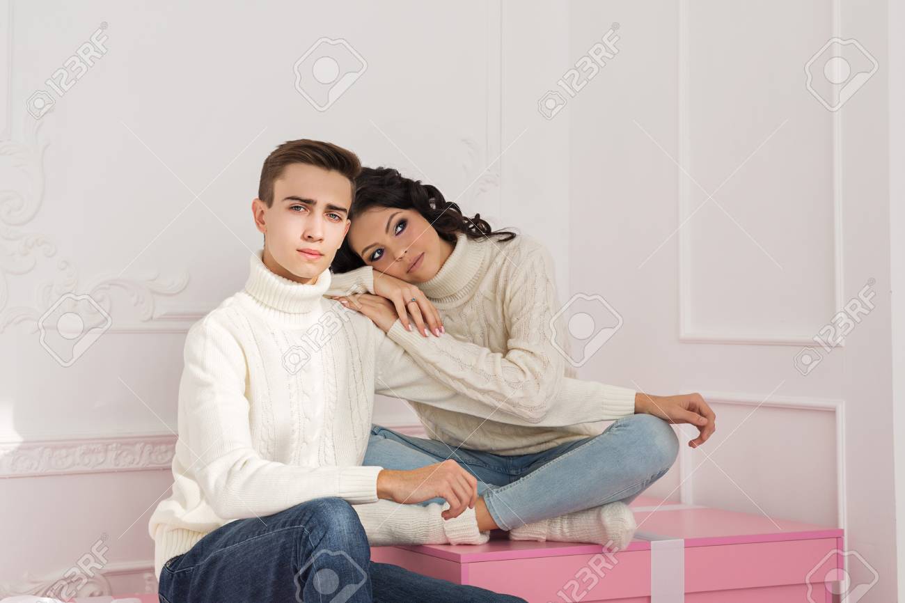 Regali Di Natale Per Giovani Coppie.Immagini Stock Una Coppia Di Giovani Innamorati E Seduta Sui Regali Indossano Gli Stessi Maglioni Bianchi Lei Appoggio La Testa Sulla Sua Spalla Vacanze Felice Anno Nuovo Buon Natale San Valentino