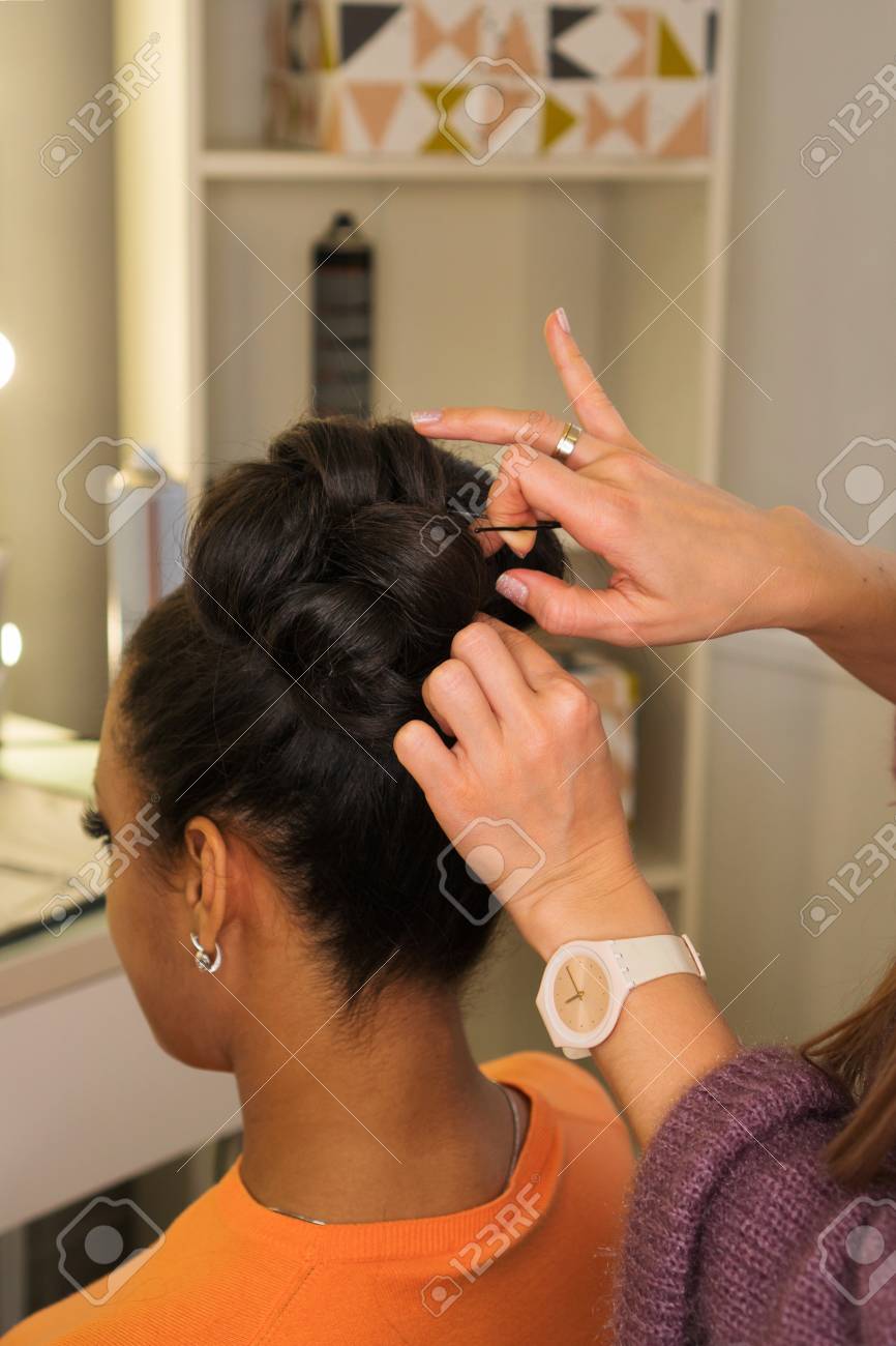 Hair Stylist Hands Form High Hairstyle On Head Of Young African