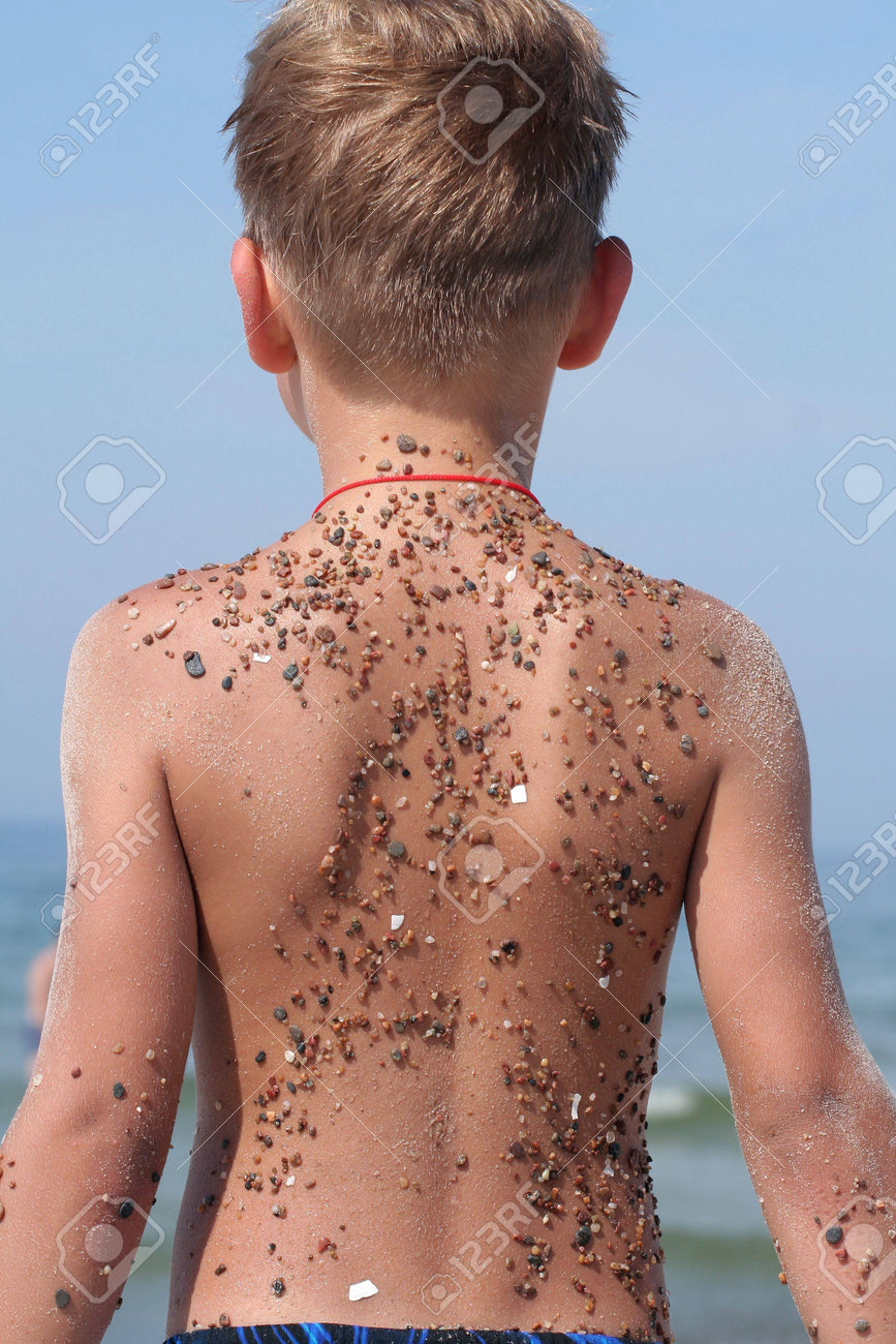 A Child S Back Covered With Small Stones And Sand Stock Photo Picture And Royalty Free Image Image