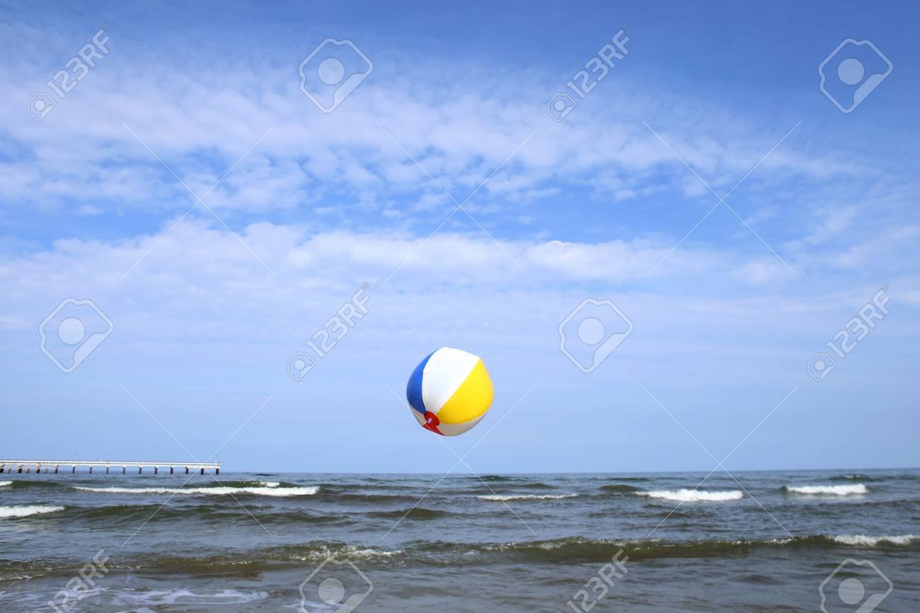 Colorful Beach Ball In Flight Over Sea. Holiday Beach Ball In The Sky On Sea  Background. Фотография, картинки, изображения и сток-фотография без роялти.  Image 103753380