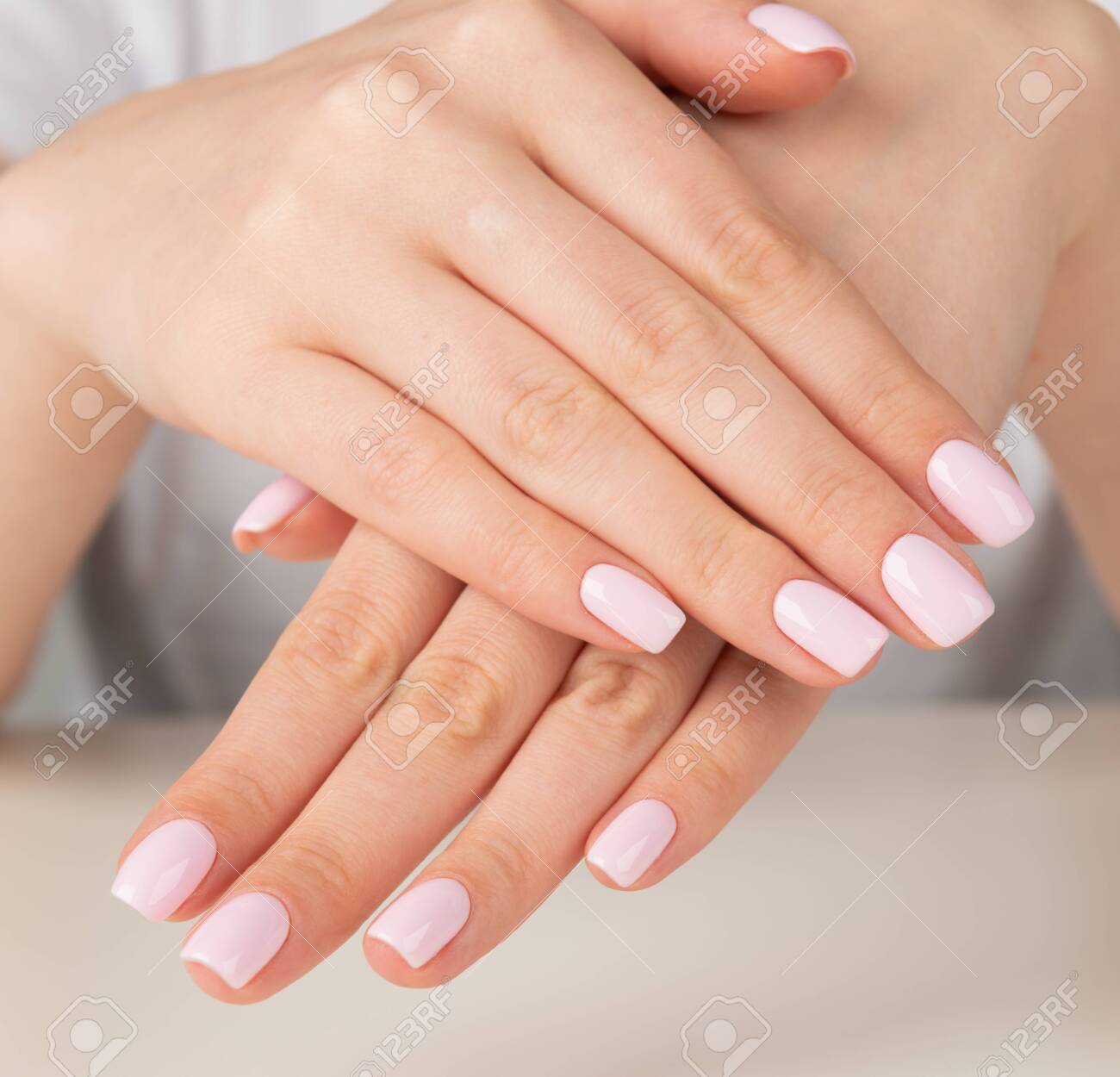 Beautiful female hand with light pink nail design. - 130952196 Beautiful female hand with light pink nail design. - 130952196