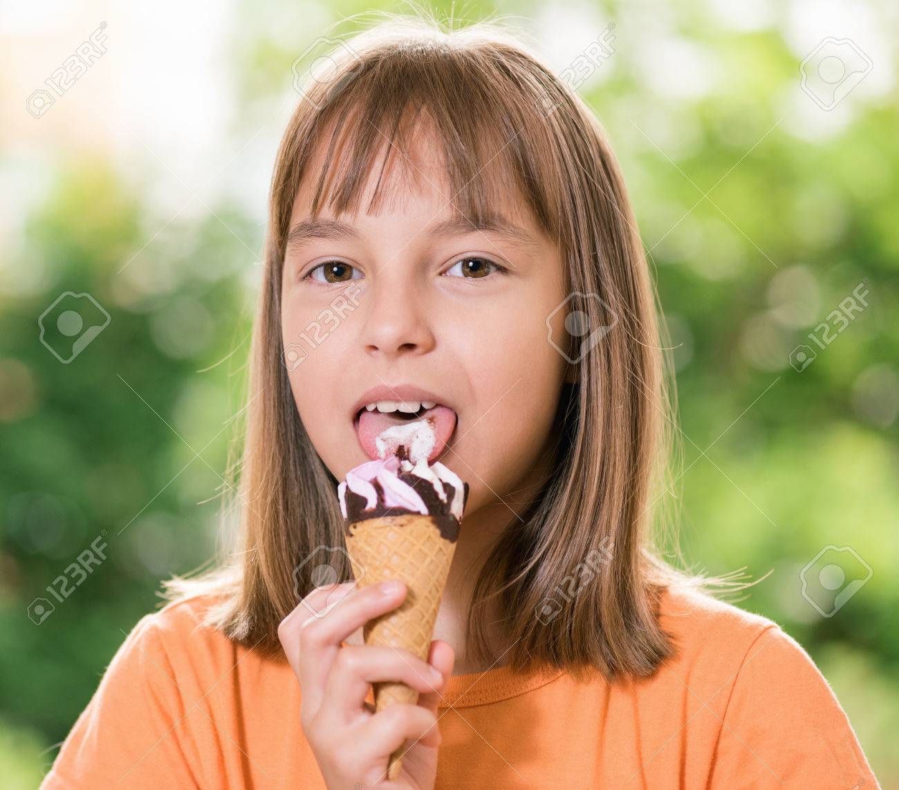 幸せな女の子 10 11 歳のアイス クリーム コーンの屋外のポートレート の写真素材 画像素材 Image