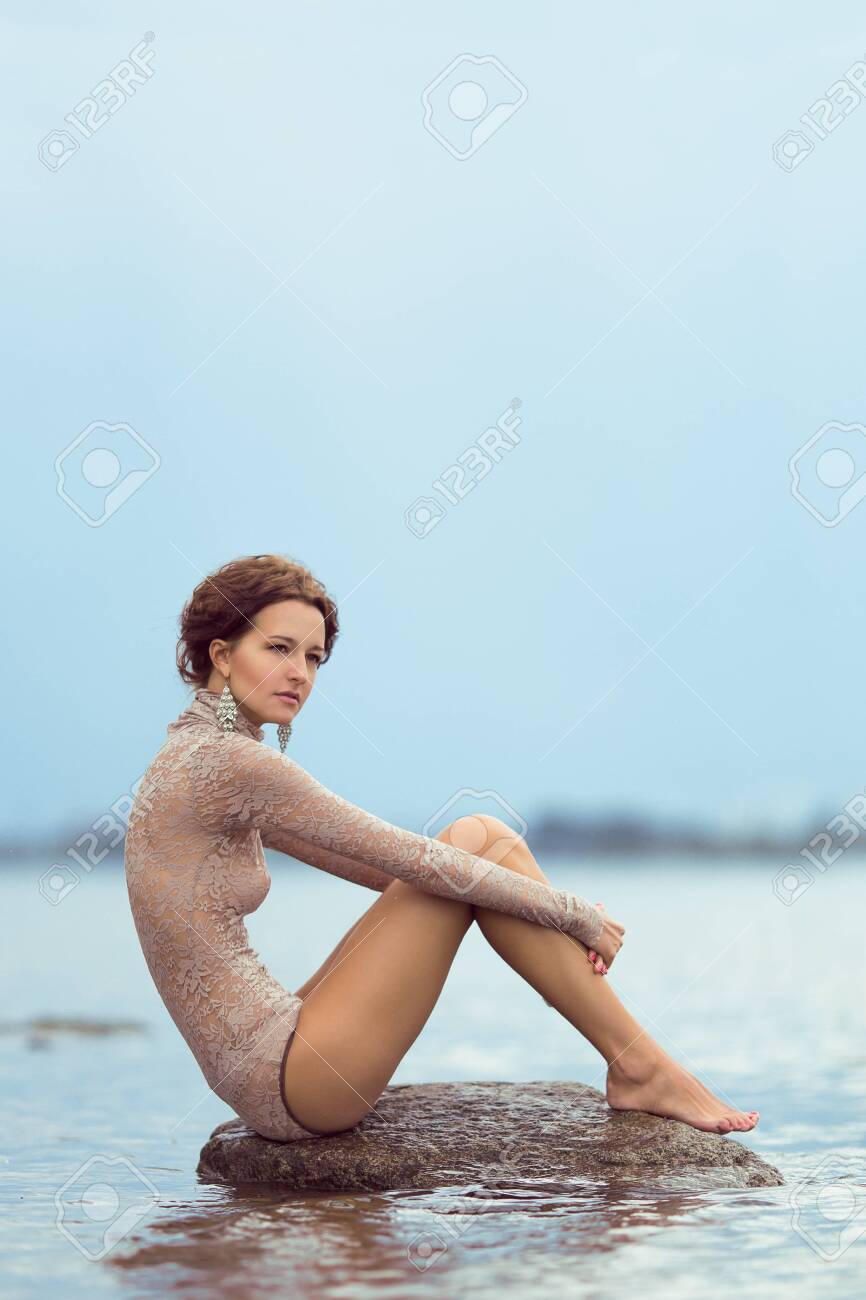 슬픈 마른 여자는 돌에 앉아 로열티 무료 사진, 그림, 이미지 그리고 스톡포토그래피. Image 59835275