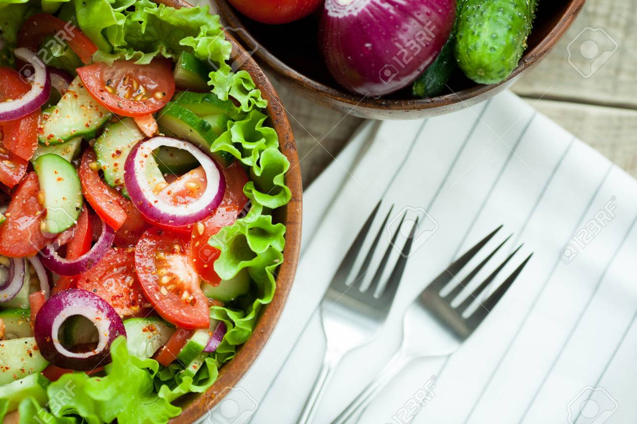 新鮮なトマト きゅうり 赤玉ねぎ レタス 素朴なサラダは 木製のボウルにオリーブ オイルとコショウと服装 平面図です の写真素材 画像素材 Image
