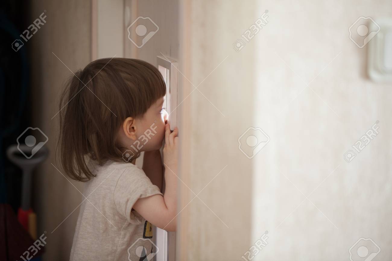 Le Petit Garçon Regarde Dans La Fenêtre De La Porte. Un Enfant Espionner  Ses Parents Derrière La Porte De La Chambre Fermée Banque D'images Et  Photos Libres De Droits. Image 86251675.