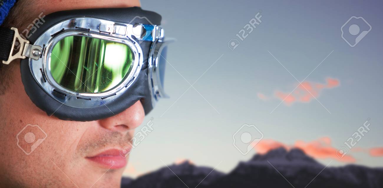 空と雪を頂いた山に対して飛行士ゴーグルを着用の男のクローズ アップ の写真素材 画像素材 Image