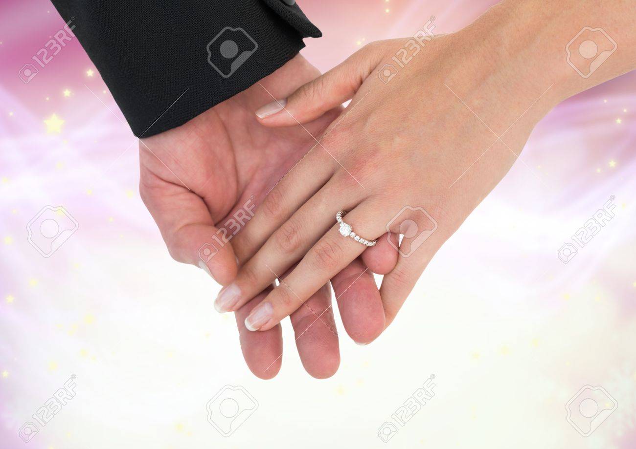 一緒に輝く光のボケ背景を持つ結婚式の婚約指輪を両手のデジタル合成 の写真素材 画像素材 Image