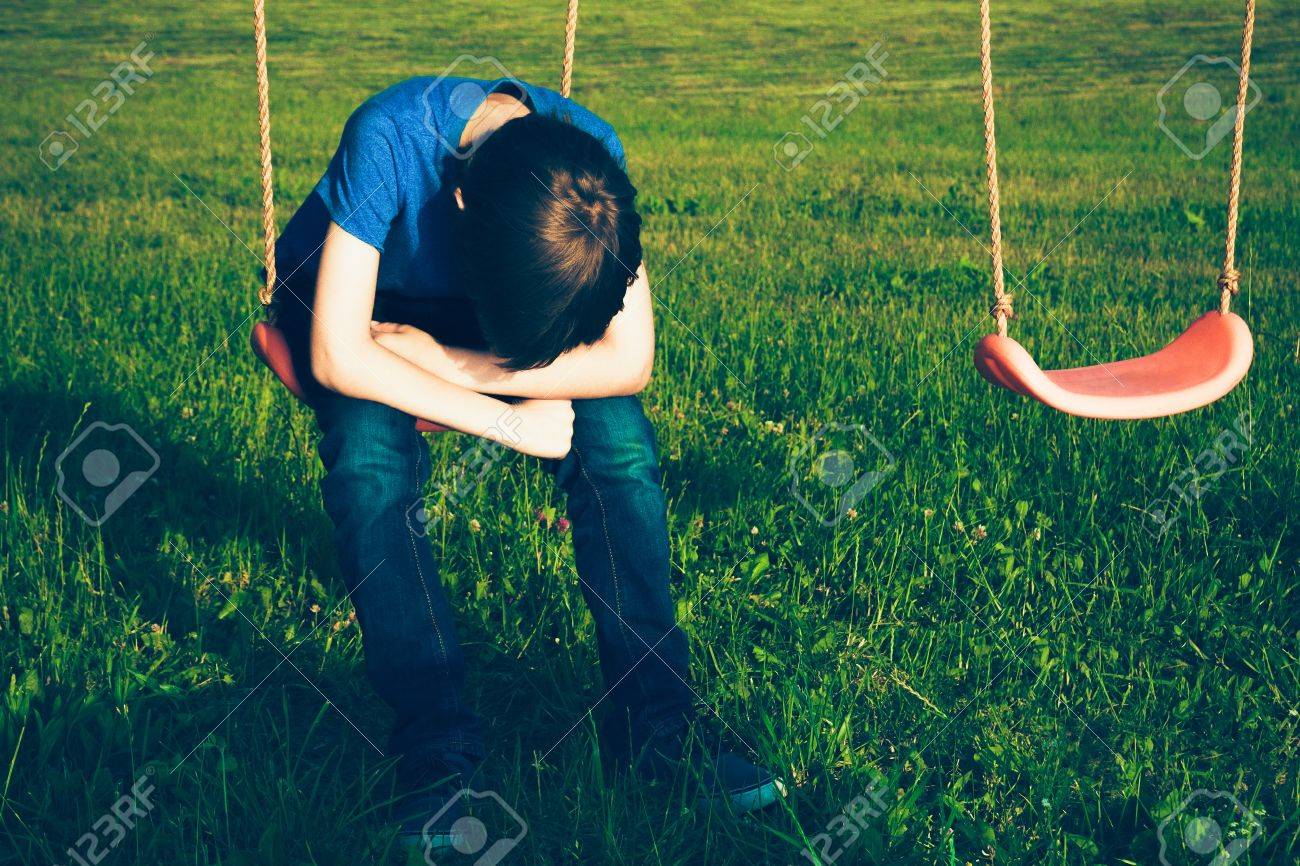 Sad lonely boy sitting on swing stock photo 80824378