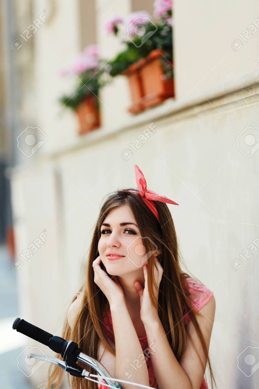 sensitive girl, looking at camera, sitting on a bicycle - 122488697 sensitive girl, looking at camera, sitting on a bicycle - 122488697