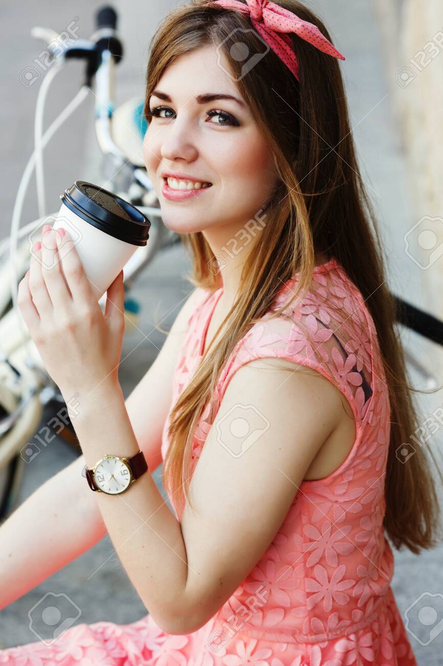 girl smiling with a cup of coffee, close-up - 122488777 girl smiling with a cup of coffee, close-up - 122488777