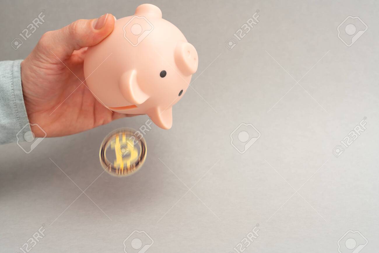 비트코인 암호화폐 판매 기호를 위한 비트코인 판매 개념 돼지 저금통 한 남자가 회색 배경 복사 공간에 있는 돈 상자에서 비트코인을  흔드는 모습 로열티 무료 사진, 그림, 이미지 그리고 스톡포토그래피. Image 147141323