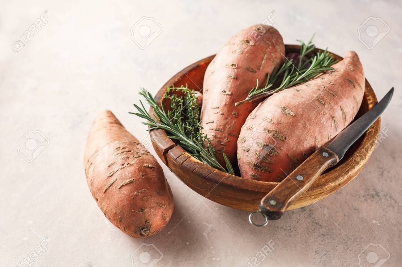 Organic sweet potatoes in a wooden bowl - 129402907 Organic sweet potatoes in a wooden bowl - 129402907