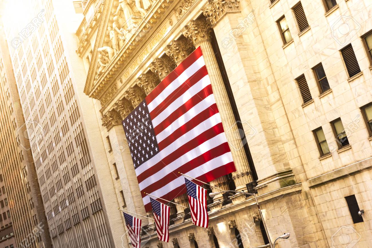 Famous Wall street and the building in New York, New York Stock Exchange with patriot flag - 82008019 Famous Wall street and the building in New York, New York Stock Exchange with patriot flag - 82008019