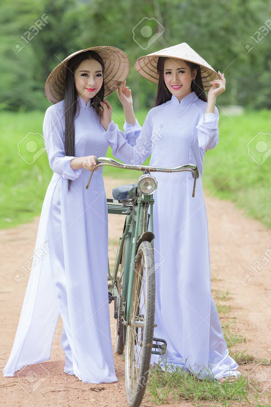 옥수수 밭, 베트남 전통 ​​의상에서 Ao Dai와의 VIetnam 소녀의 초상, Ao Dai는 VIetnam에서 여성을위한 유명한  전통 의상입니다. 로열티 무료 사진, 그림, 이미지 그리고 스톡포토그래피. Image 72156347