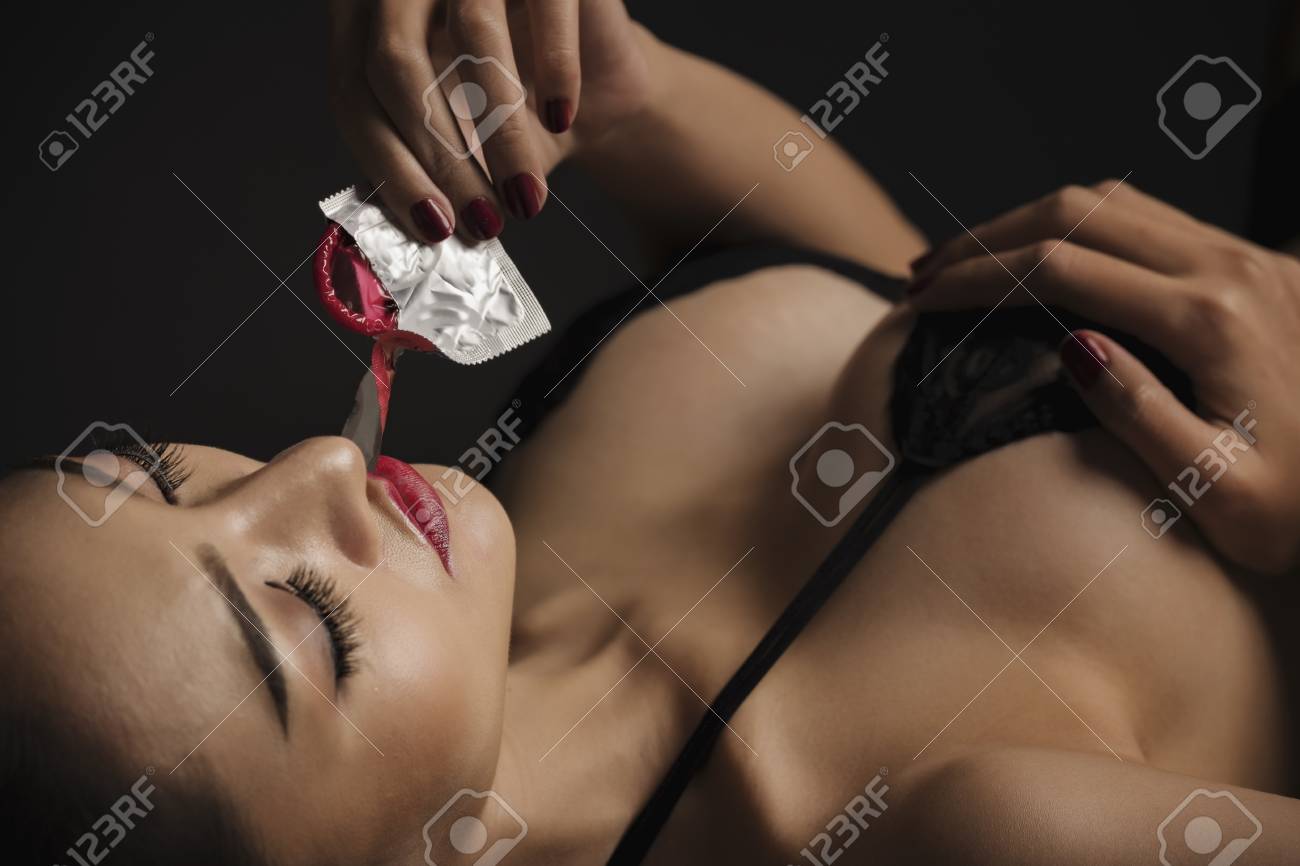 セクシーな唇 口を開けて女性の手にコンドーム コンドームは女性が示すように 保護 安全なセックスの概念について覚えています 避妊 避妊 の写真素材 画像素材 Image
