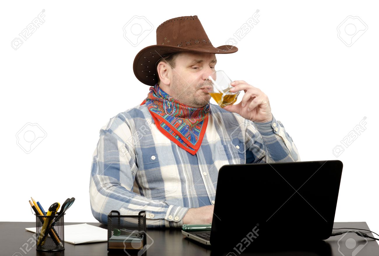 Cowboy Looking Latest News Online On Laptop And Drinking Whiskey Stock Photo Picture And Royalty Free Image Image
