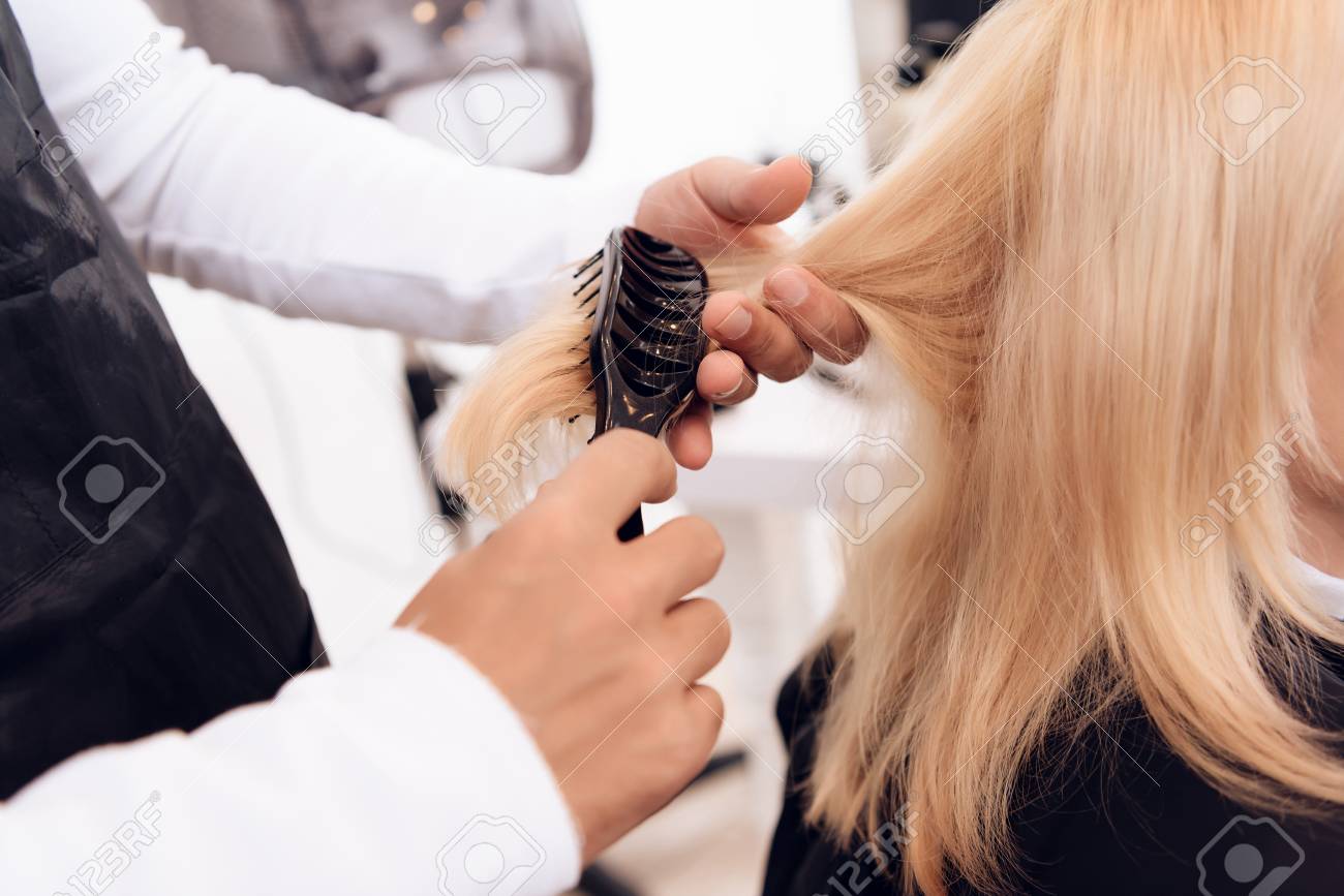Close Up Hairdresser S Hands Comb Out Straight Blonde Hair Of