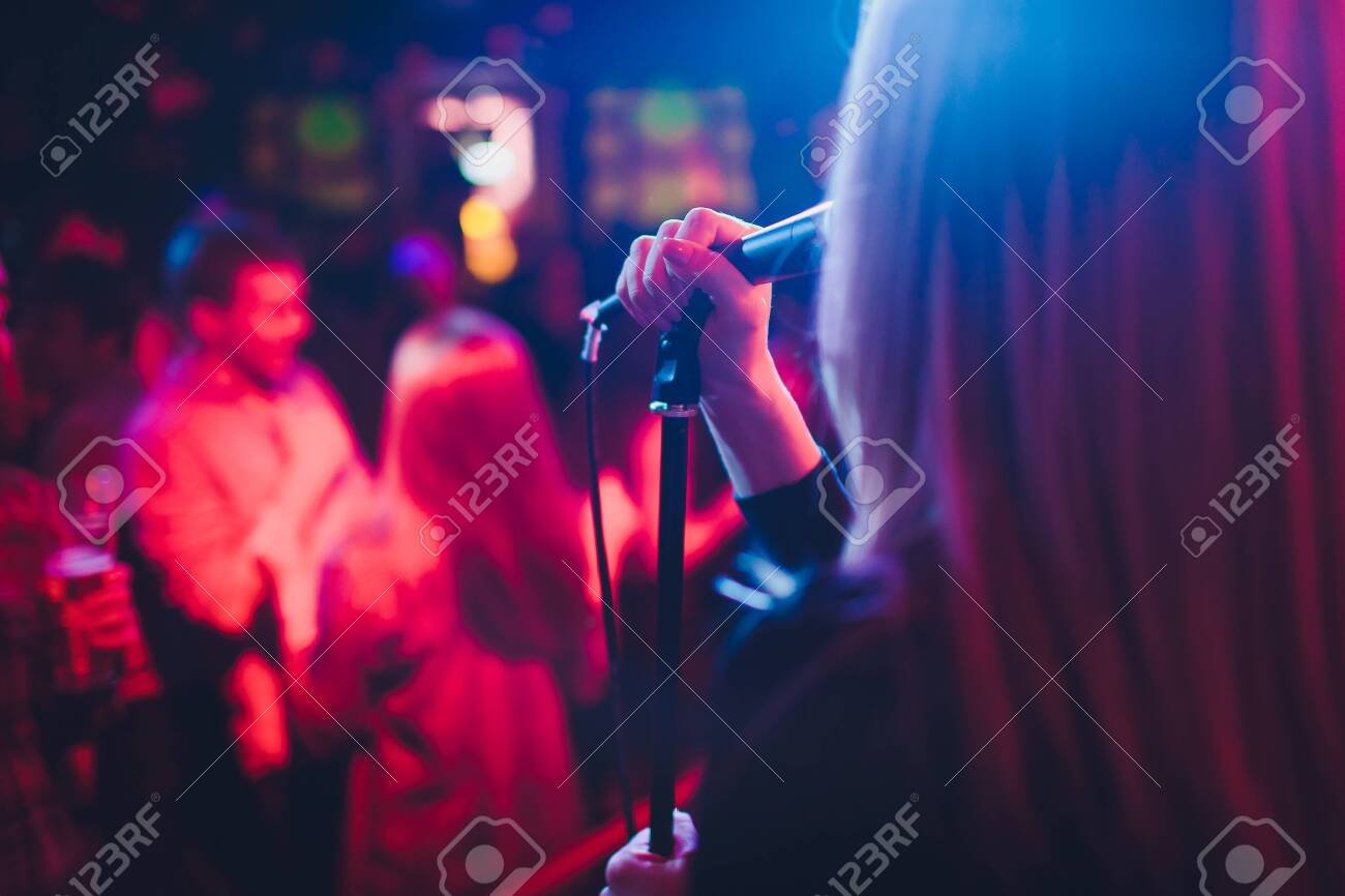 Entertianment at a wedding. A female singer is interacting with the crowd while a man plays an acoustic guitar. - 118565946 Entertianment at a wedding. A female singer is interacting with the crowd while a man plays an acoustic guitar. - 118565946