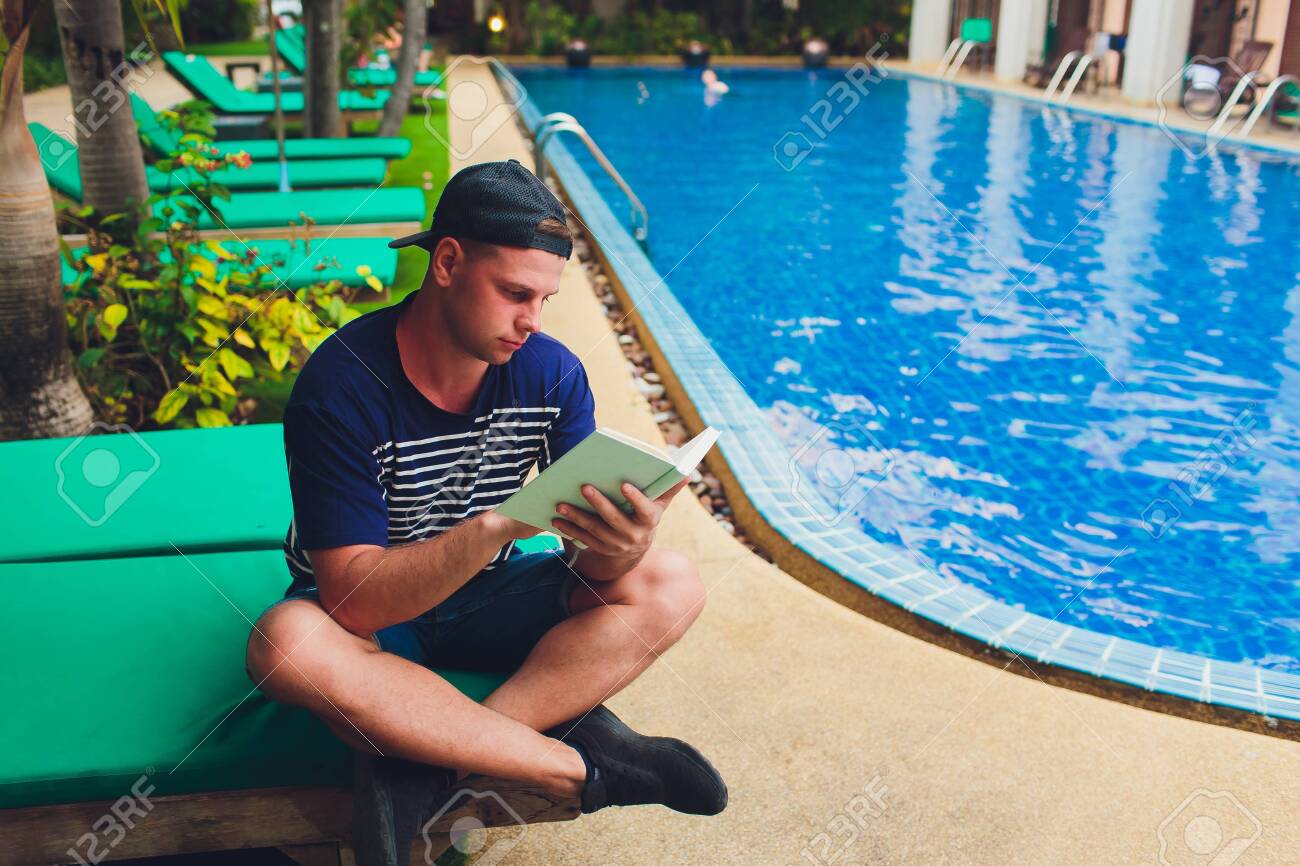 庭プール 男女の裸 庭のプールの横で本を読んでいる男の写真素材・画像素材 Image 120588025