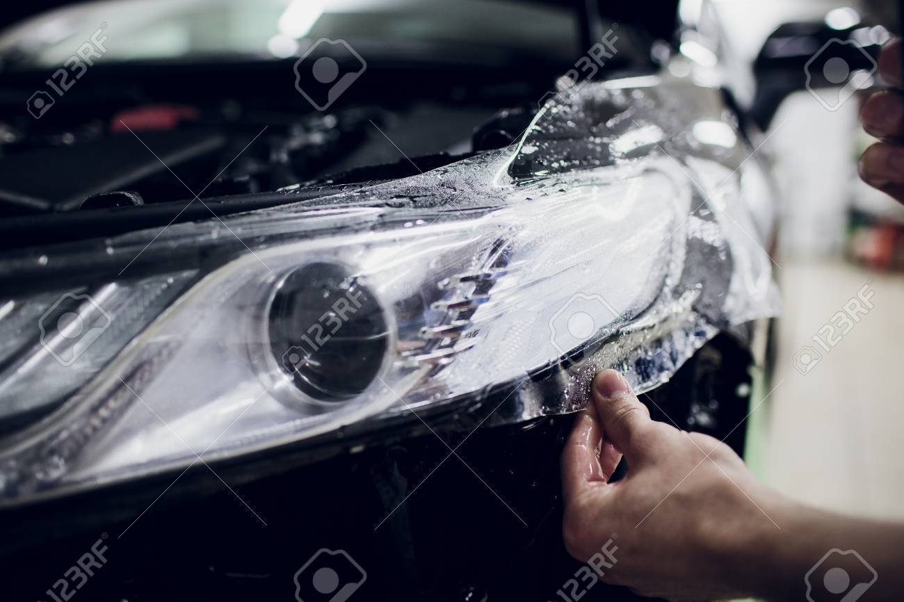 Paint Protection Film >> Worker Hands Installs Car Paint Protection Film Wrap Auto Headlight Paint Protection Film >> Worker Hands Installs Car Paint Protection Film Wrap Auto Headlight
