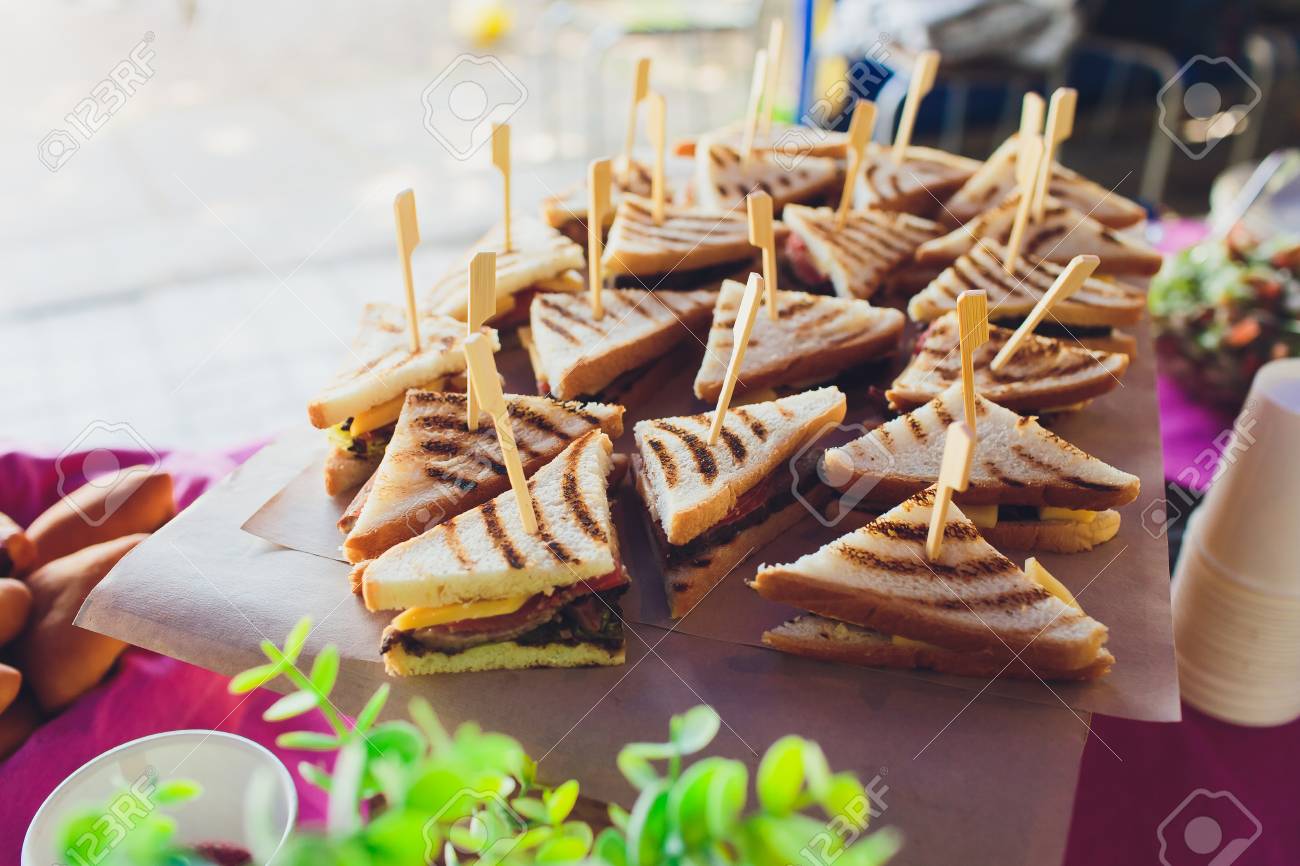 Cut platter of mixed sandwich triangles, on the buffet table - 124644757 Cut platter of mixed sandwich triangles, on the buffet table - 124644757