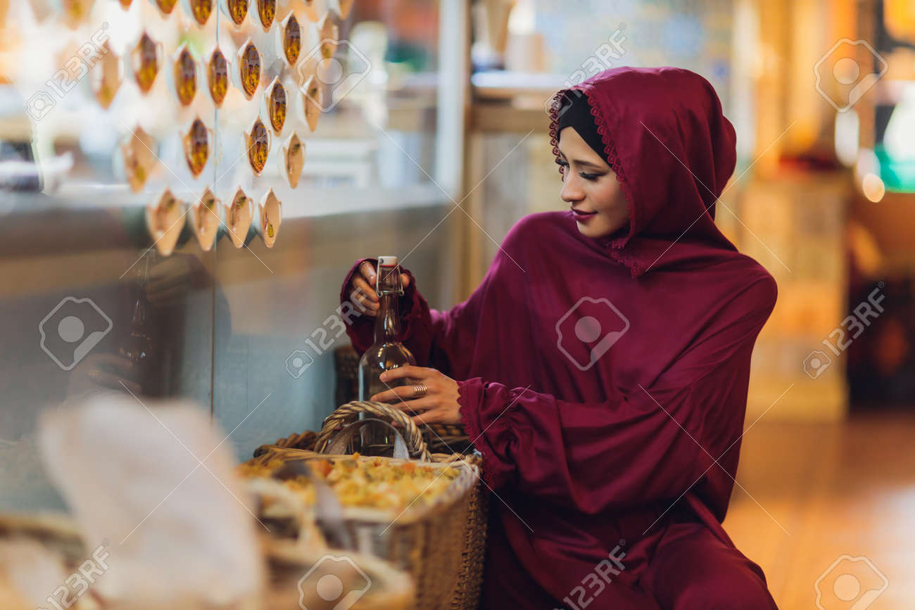 Arabian young muslim woman sitting in a cafe. - 169483490 Arabian young muslim woman sitting in a cafe. - 169483490