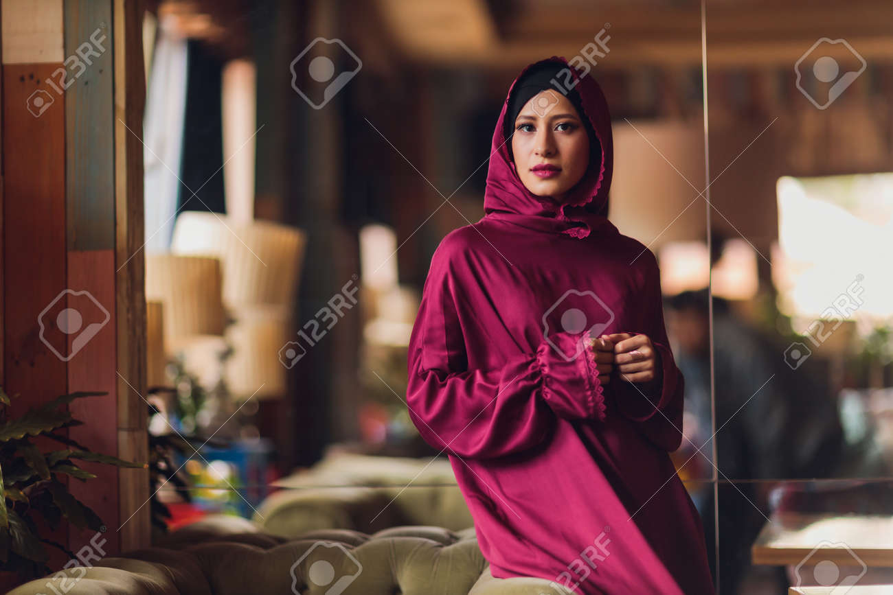 Arabian young muslim woman sitting in a cafe. - 169483497 Arabian young muslim woman sitting in a cafe. - 169483497
