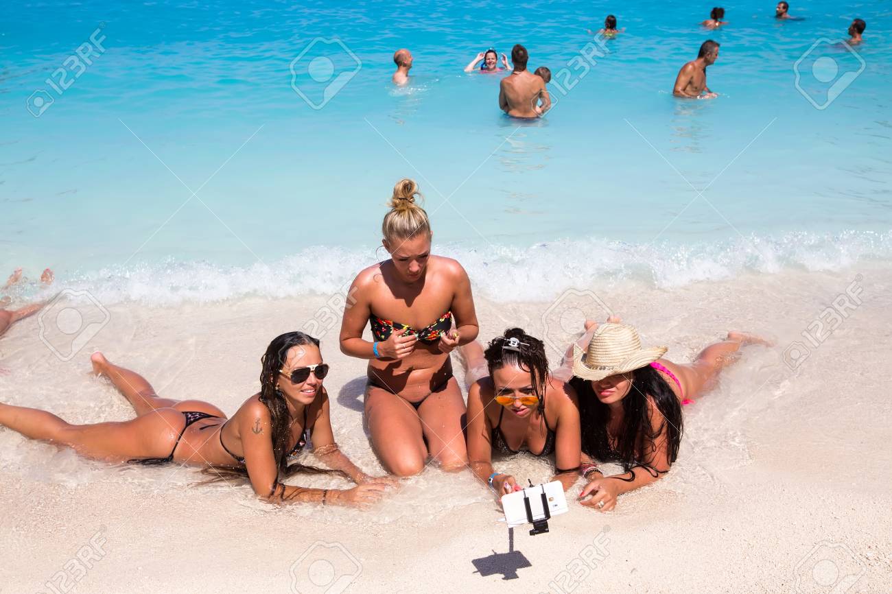 Zakynthos, Greece - August 11, 2015: Tourist Girls Doing A Selfie At The  Seaside Of Navagio Beach In Zakynthos, Greece. Navagio Beach Is A Popular  Attraction Among Tourists Stock Photo, Picture and