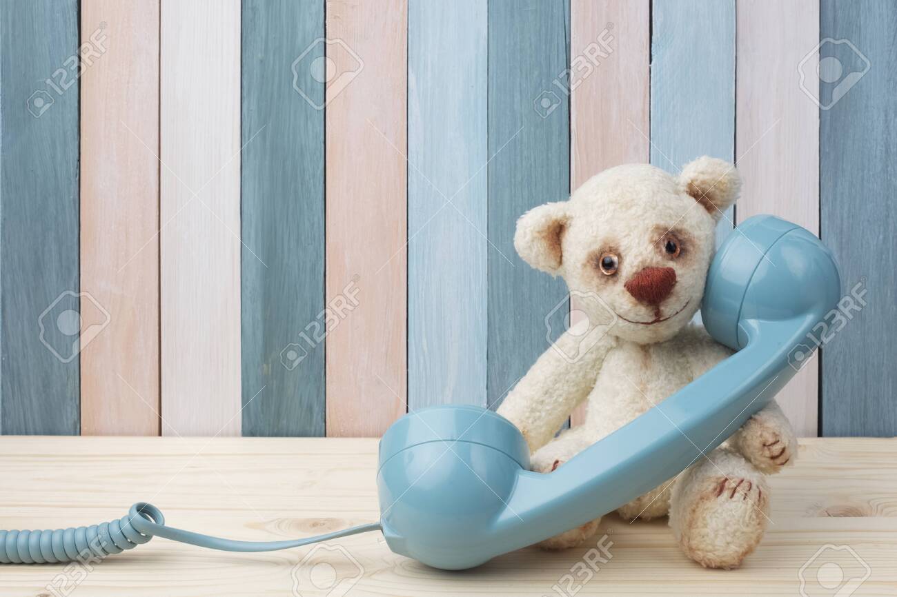 Vintage Teddy Bear with retro telephone on wooden background - 122222939 Vintage Teddy Bear with retro telephone on wooden background - 122222939