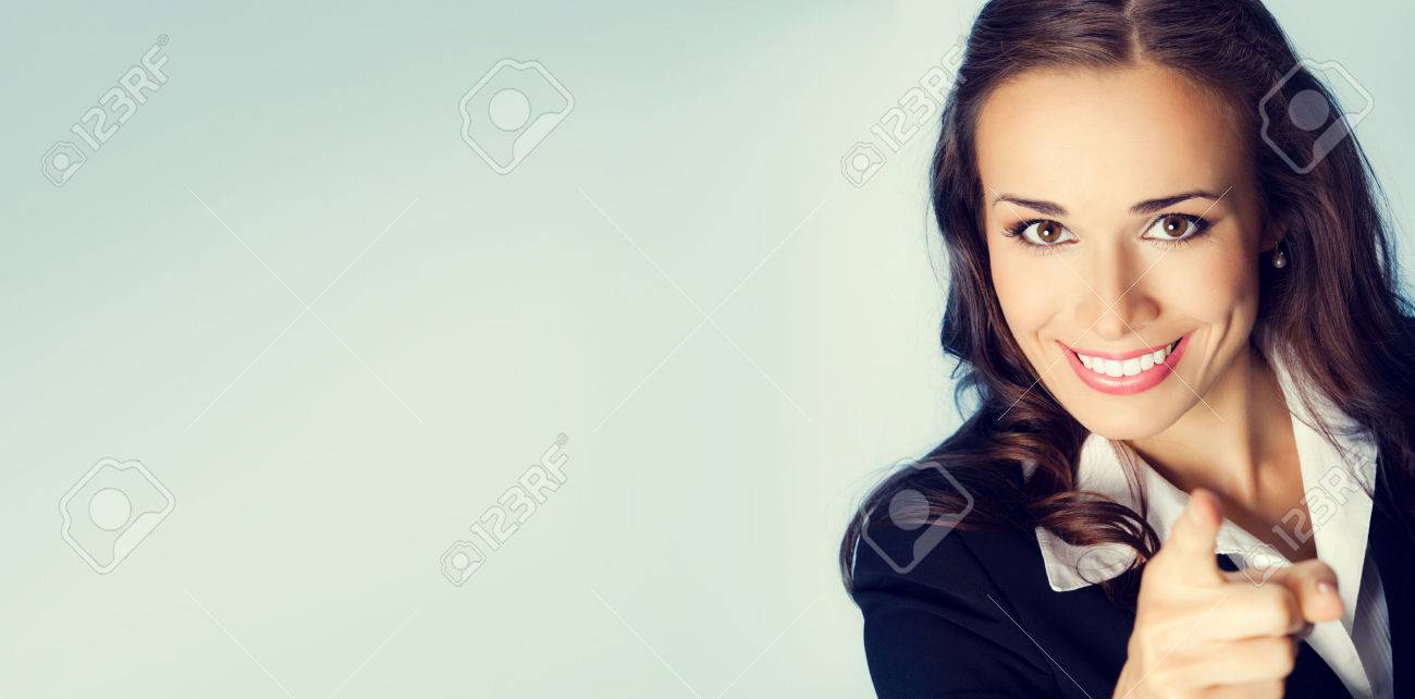 Portrait of young smiling brunette businesswoman pointing finger at viewer, with blank copyspace area for slogan or text message - 44407458 Portrait of young smiling brunette businesswoman pointing finger at viewer, with blank copyspace area for slogan or text message - 44407458