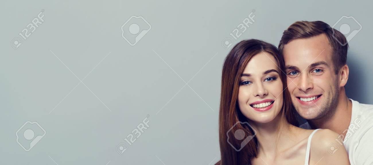 Portrait of young couple, looking at you. Caucasian models - love, relationship, dating, happy lovers, concept, against grey, with copyspace for slogan or text message. Horizontal banner composition. - 75499568 Portrait of young couple, looking at you. Caucasian models - love, relationship, dating, happy lovers, concept, against grey, with copyspace for slogan or text message. Horizontal banner composition. - 75499568