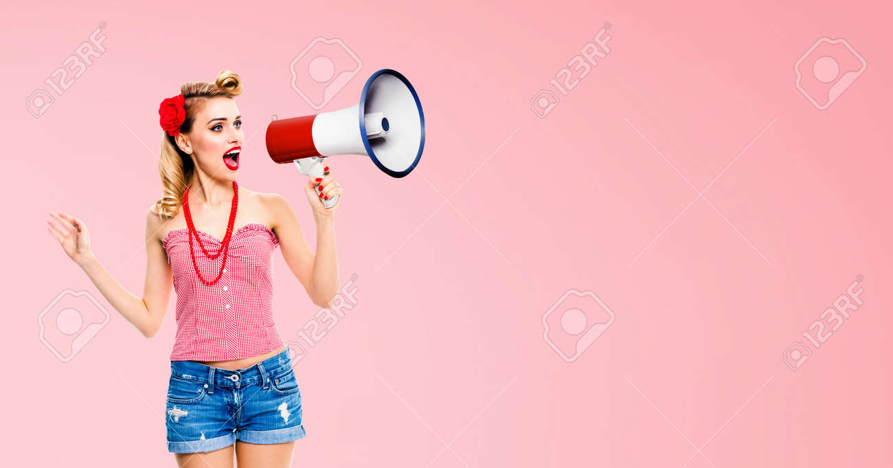 Image of blond haired woman holding megaphone, shout something. Girl in red pin up style, isolated over rose pink colour back. Female model in retro vintage studio concept. - 171535821 Image of blond haired woman holding megaphone, shout something. Girl in red pin up style, isolated over rose pink colour back. Female model in retro vintage studio concept. - 171535821