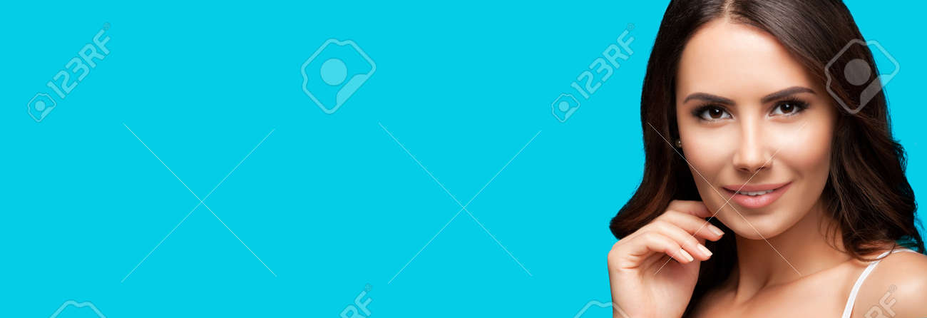 Portrait of smiling beautiful woman in white casual tank top, over aqua blue green background. Brunette girl at studio beauty fashion concept. Wide horizontal banner composition. - 171582170 Portrait of smiling beautiful woman in white casual tank top, over aqua blue green background. Brunette girl at studio beauty fashion concept. Wide horizontal banner composition. - 171582170