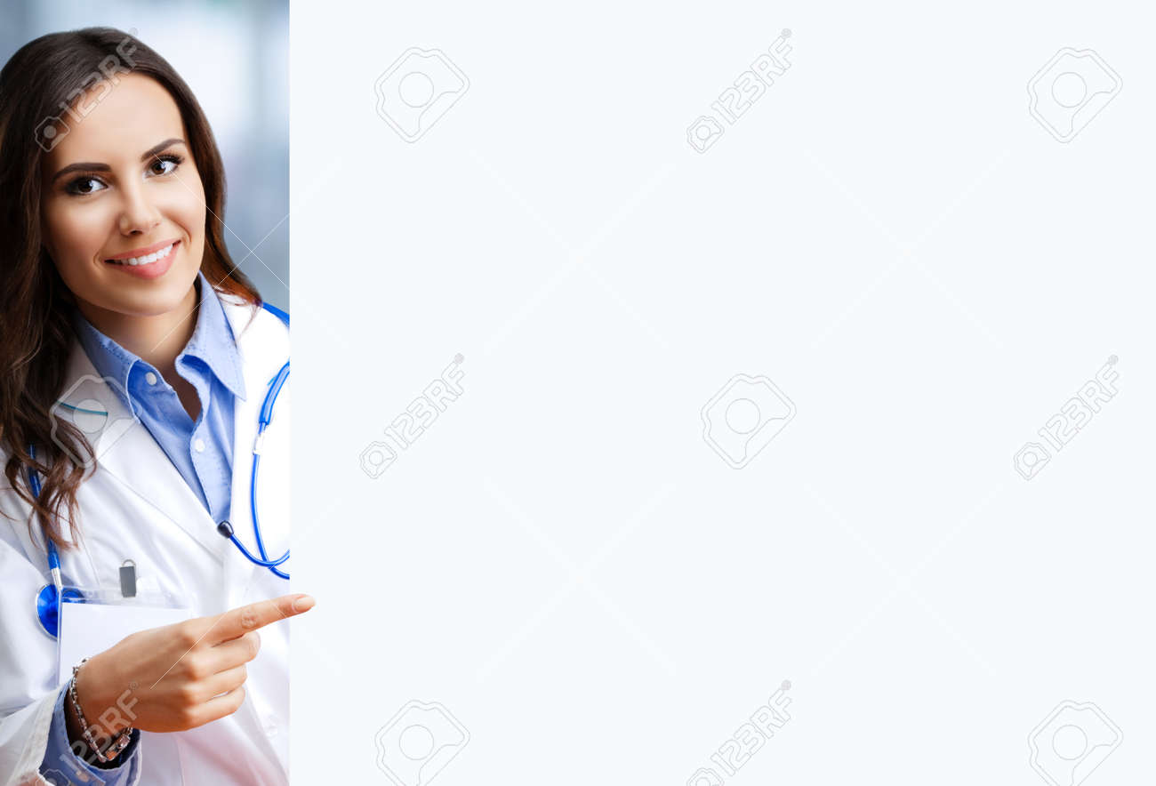 Portrait image of smiling female doctor pointing blank signboard with copy space empty area for some text, at office. Young brunette woman in medical, clinic, healthcare concept - 171585155 Portrait image of smiling female doctor pointing blank signboard with copy space empty area for some text, at office. Young brunette woman in medical, clinic, healthcare concept - 171585155