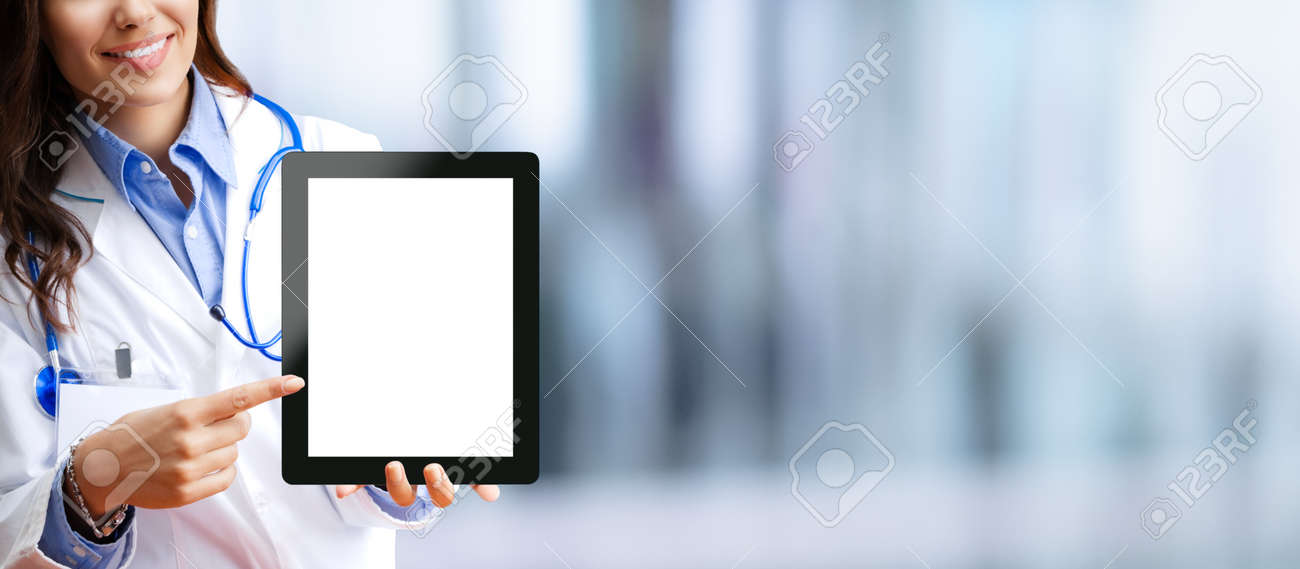 Close up of happy smiling female doctor showing tablet pc touchpad with blank copy space area for some text, over blurred modern office background. Medical help call center concept. - 171588156 Close up of happy smiling female doctor showing tablet pc touchpad with blank copy space area for some text, over blurred modern office background. Medical help call center concept. - 171588156