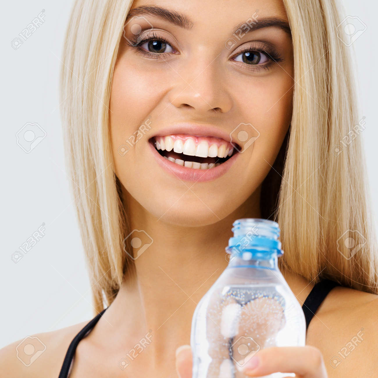 Image of happy smiling young blond woman with bottle of water, over grey background. Female fitness instructor or personal trainer at studio shot. Health, beauty and fitness concept. - 171730380 Image of happy smiling young blond woman with bottle of water, over grey background. Female fitness instructor or personal trainer at studio shot. Health, beauty and fitness concept. - 171730380