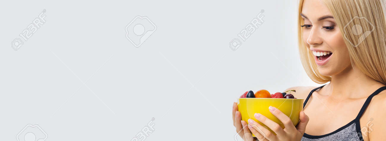 Image of happy excited woman holding yellow bowl plate of fruits, over grey background with copy space. Beautiful blond amazed smiling girl in dieting, loss weight and fitness concept. - 171730467 Image of happy excited woman holding yellow bowl plate of fruits, over grey background with copy space. Beautiful blond amazed smiling girl in dieting, loss weight and fitness concept. - 171730467