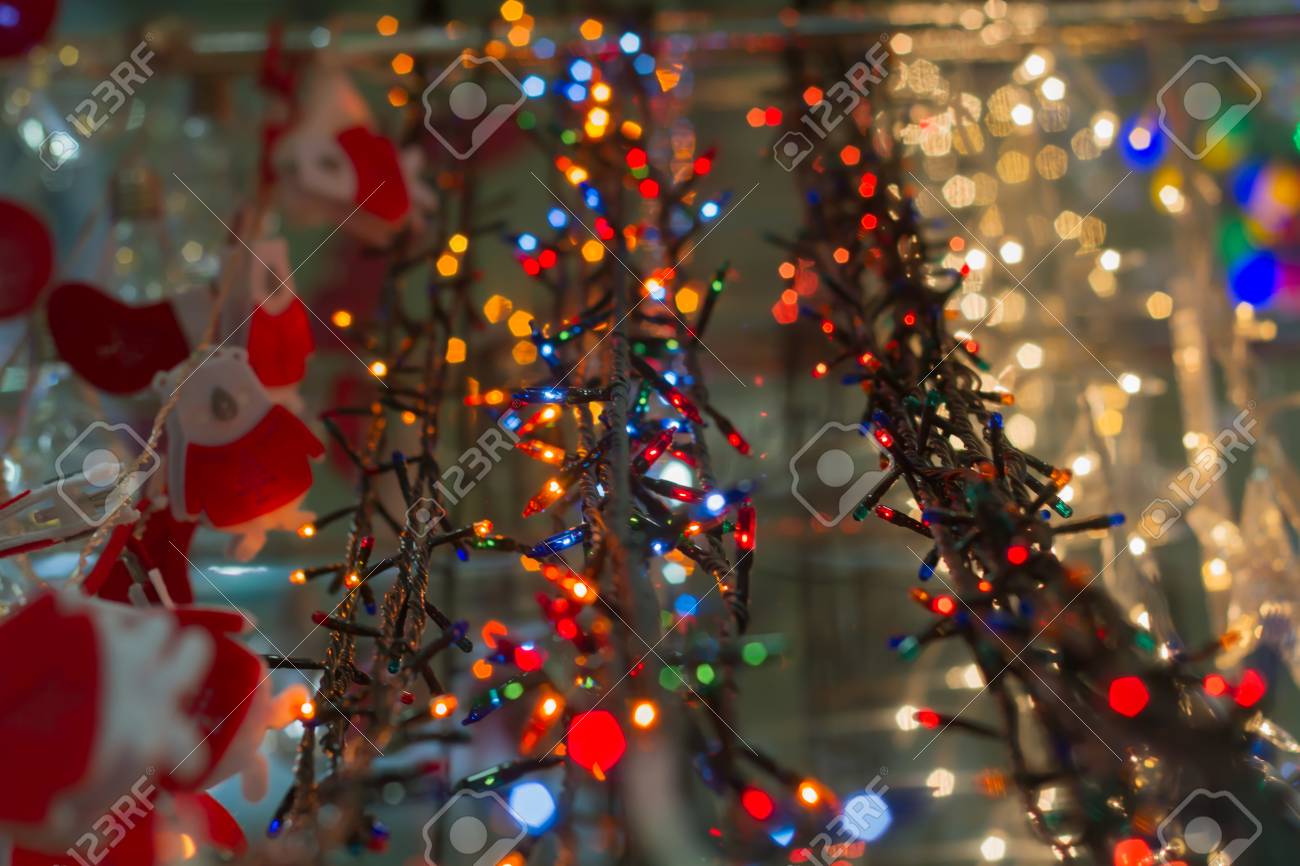 Luces De Navidad Eléctricas Como Objeto En Supermercado, Tienda En Venta. Una Amplia Gama, Una Variedad De Coloridas Guirnaldas Decorativas. Fondo Abstracto Fotos, Retratos, Imágenes Fotografía De Archivo Libres De Derecho.