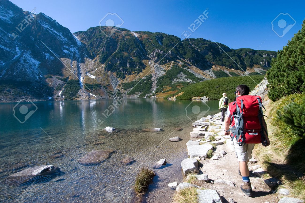 Couple trekking by the side of mountain pond in Tatra Mountains, Poland - 1727445 Couple trekking by the side of mountain pond in Tatra Mountains, Poland - 1727445