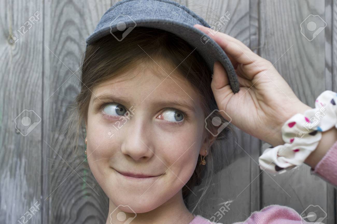 バック グラウンドで木製の壁側の視線とすぼめ 7 の面白い女の子の肖像画 の写真素材 画像素材 Image