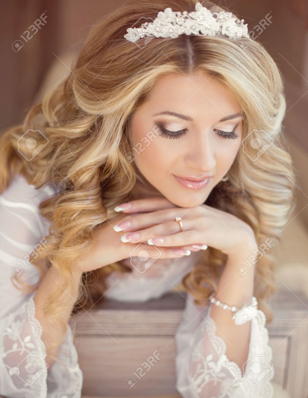 Banque d\u0027images , Belle femme mariée portrait intérieur. Maquillage et coiffure ondulée. Ongles manucurés. Jour de mariage du matin.