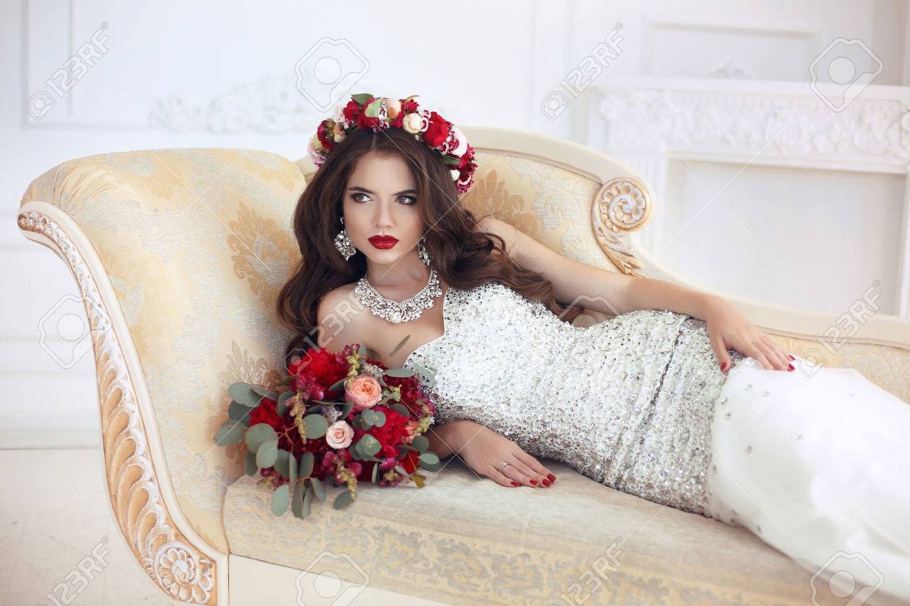 Schoner Brunette Braut Hochzeit Portrat Rote Lippen Make Up Lange Welligen Frisur Teure Diamant Schmuck Brautstrauss Aus Blumen Elegante Dame Auf Modernen Sofa Im Weissen Innenraum Liegen Lizenzfreie Fotos Bilder Und Stock Fotografie Image