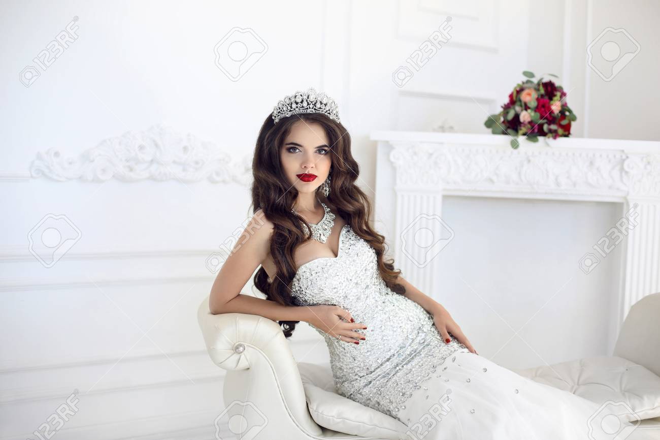 Schoner Brunette Braut Hochzeit Portrat Rote Lippen Make Up Lange Welligen Frisur Teure Diamant Schmuck Brautstrauss Aus Blumen Elegante Dame Auf Modernen Sofa Im Weissen Innenraum Liegen Lizenzfreie Fotos Bilder Und Stock Fotografie Image